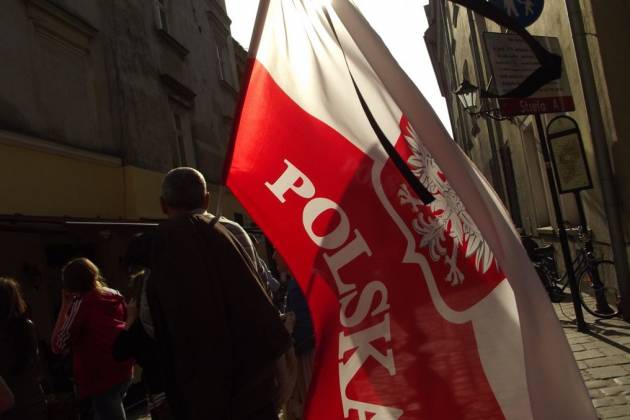 A man with a Polish flag in the old city of Cracow A man with a Polish flag in the old city of Cracow