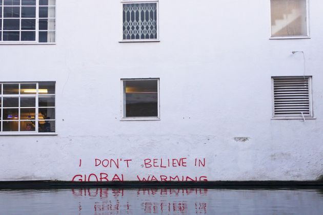 Napis na podtopionym budynku "I don't believe in global warming"